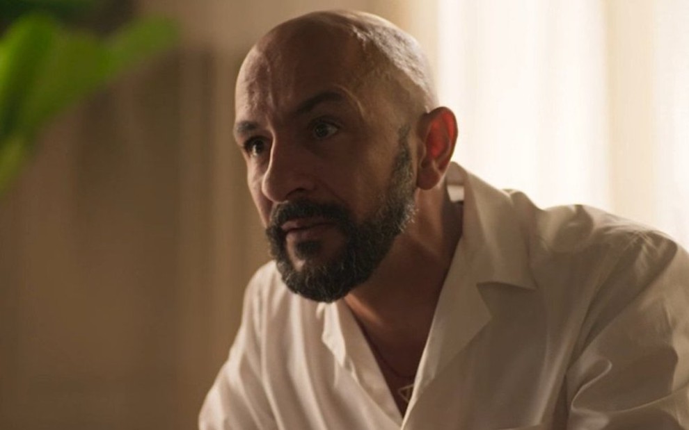 O ator Irandhir Santos faz uma expressão de desespero em cena da novela Amor de Mãe em que usa uma camisa clara