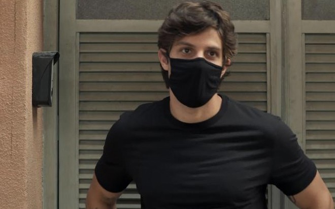 O ator Chay Suede com uma máscara preta caracterizado como Danilo em cena de Amor de Mãe