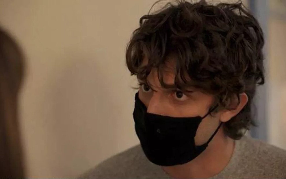 O ator Chay Suede, com máscara de proteção, em cena de Amor de Mãe