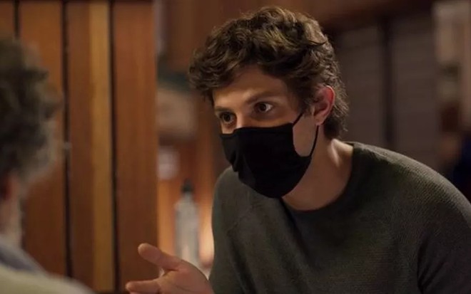 O ator Chay Suede, com máscara de proteção, em cena de Amor de Mãe