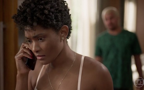 A atriz Erika Januza com os olhos arregalados fala ao celular como a Marina em cena de Amor de Mãe