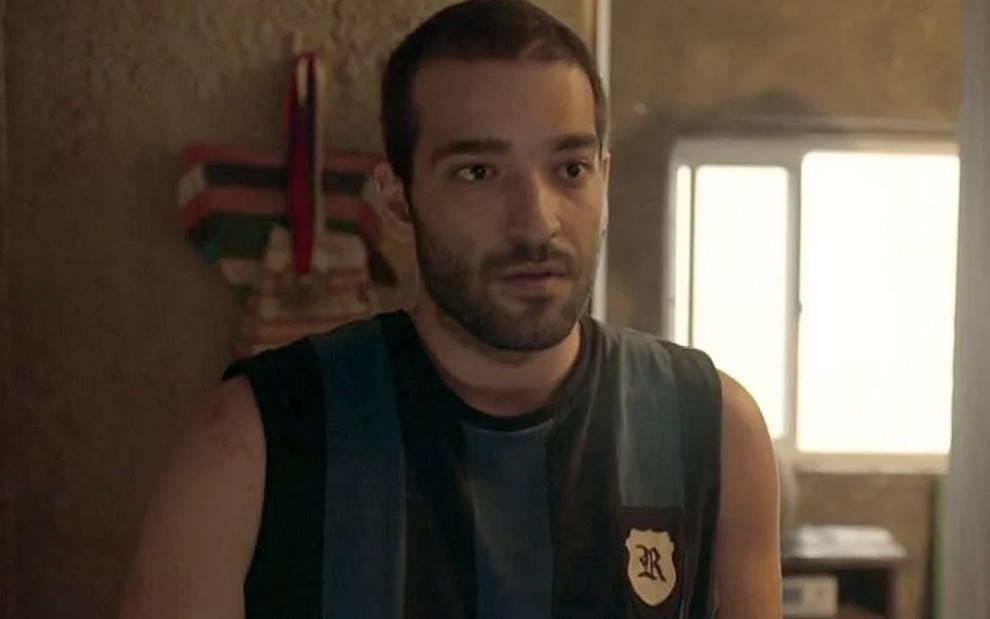 O ator Humberto Carrão com expressão de surpresa como Sandro em cena de Amor de Mãe