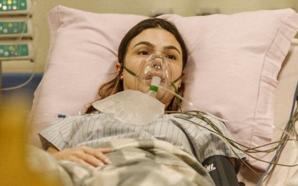 A personagem Betina (Isis Valverde) deitada em uma cama de UTI em cena da novela Amor de Mãe, da Globo