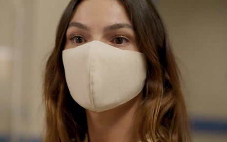 A atriz Isis Valverde, com máscara de proteção branca, em cena como Betina em Amor de Mãe