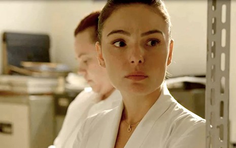 A atriz Isis Valverde, com jaleco branco de enfermeira, caracterizada como Betina em Amor de Mãe