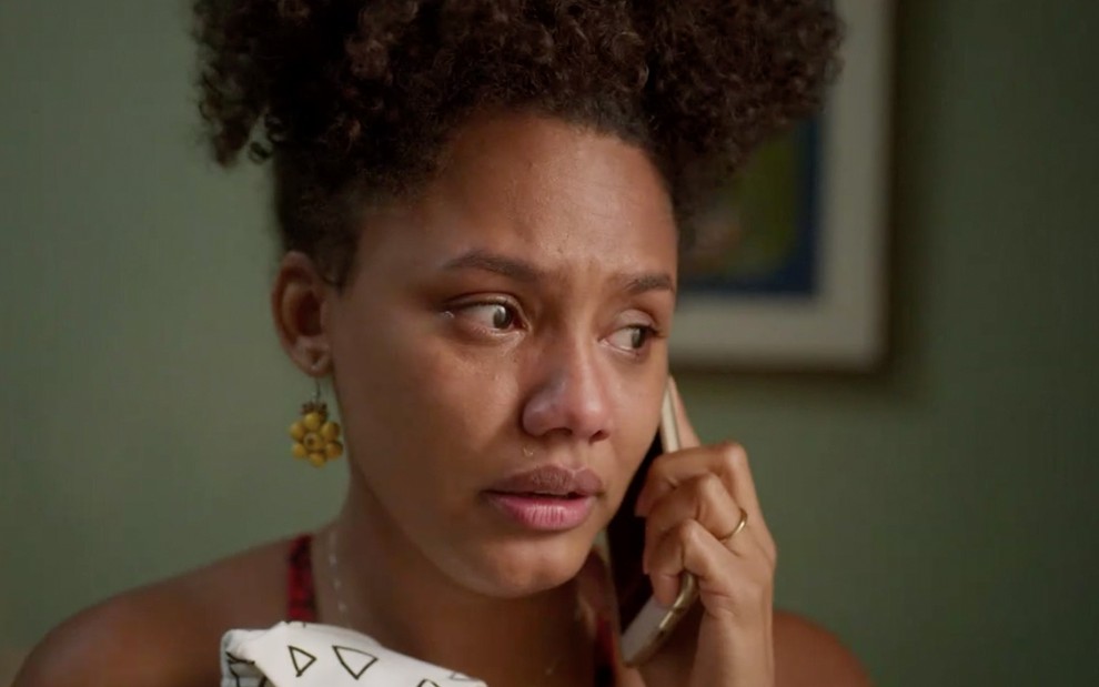 A atriz Jéssica Ellen fala ao telefone com lágrimas nos olhos como Camila em cena de Amor de Mãe