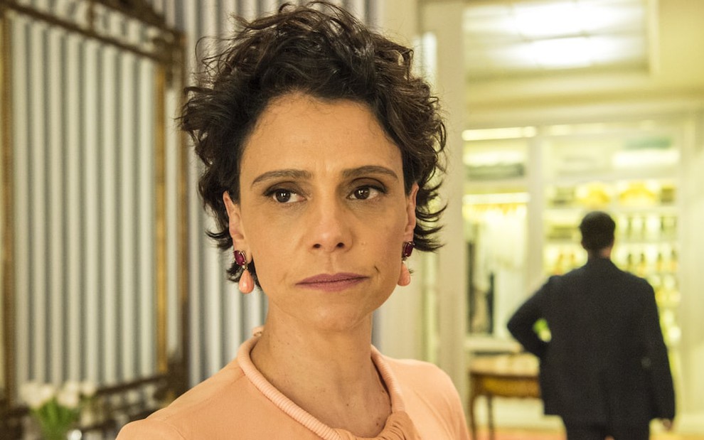A atriz Malu Galli posa com expressão de raiva em cenário de sua personagem na novela Amor de Mãe, da TV Globo