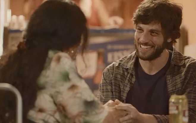 Regina Casé segura as mãos e conversa com Chay Suede, que sorri e tem lágrimas nos olhos, em cena de Amor de Mãe