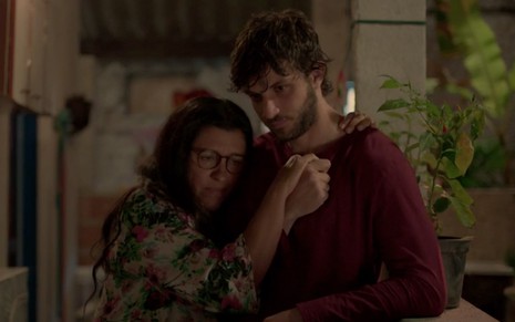 Regina Casé e Chay Suede caracterizados como Lurdes e Danilo em Amor de Mãe: em clima melancólico, personagens se abraçam