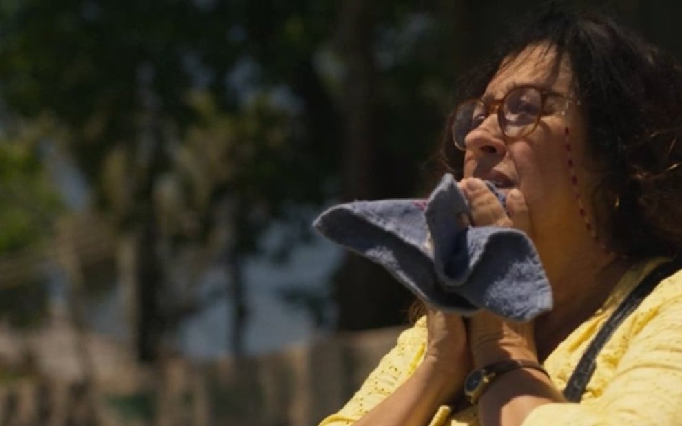 A atriz Regina Casé com uma toalhinha nas mãos faz uma prece em cena da novela Amor de Mãe, da TV Globo