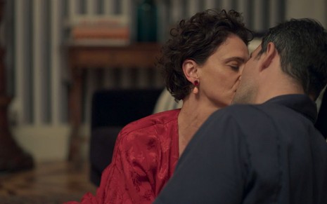 Lídia (Malu Galli) e Magno (Juliano Cazarré) se beijam sentados no chão em cena de Amor de Mãe
