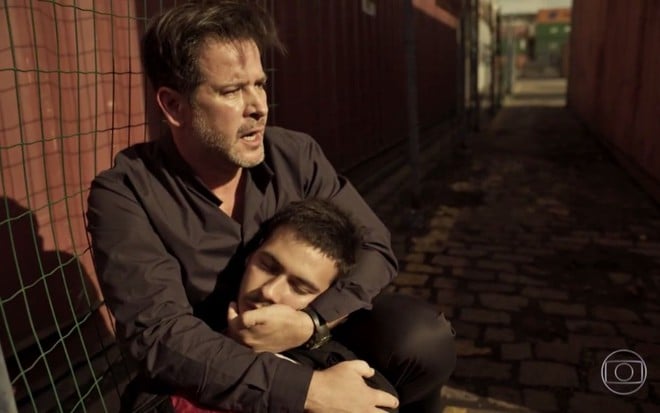 O personagem Raul (Murilo Benício) segura o personagem baleado Vinícius (Antonio Benicio) em Amor de Mãe