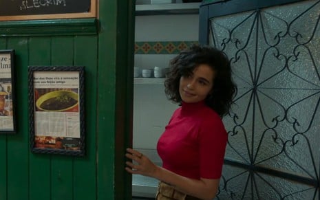 A atriz Nanda Costa, com uma blusa vermelha, em cena como Érica em Amor de Mãe
