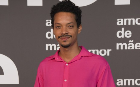 O ator Nando Brandão, posando para foto com uma camisa cor de rosa