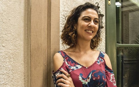 A atriz Clarissa Pinheiro sorri ao posar nos bastidores da novela Amor de Mãe caracterizada como a empregada Penha