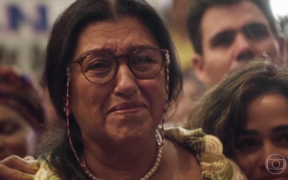 A atriz Regina Casé chora como Lurdes durante uma festa de formatura em cena de Amor de Mãe