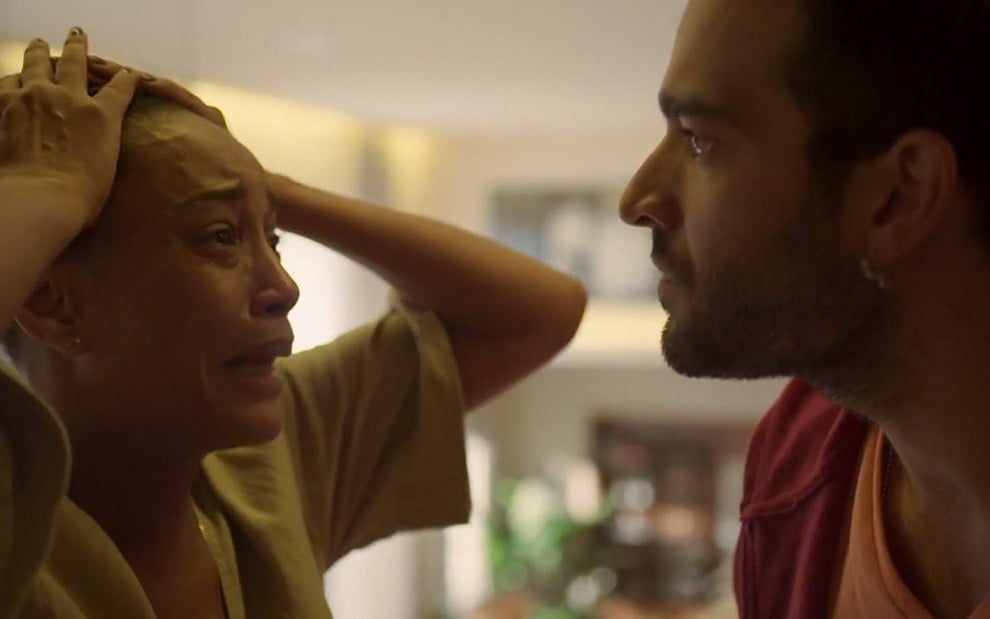 Vitória (Taís Araujo) leva as mãos à cabeça, desesperada, diante de Sandro (Humberto Carrão) em cena de Amor de Mãe