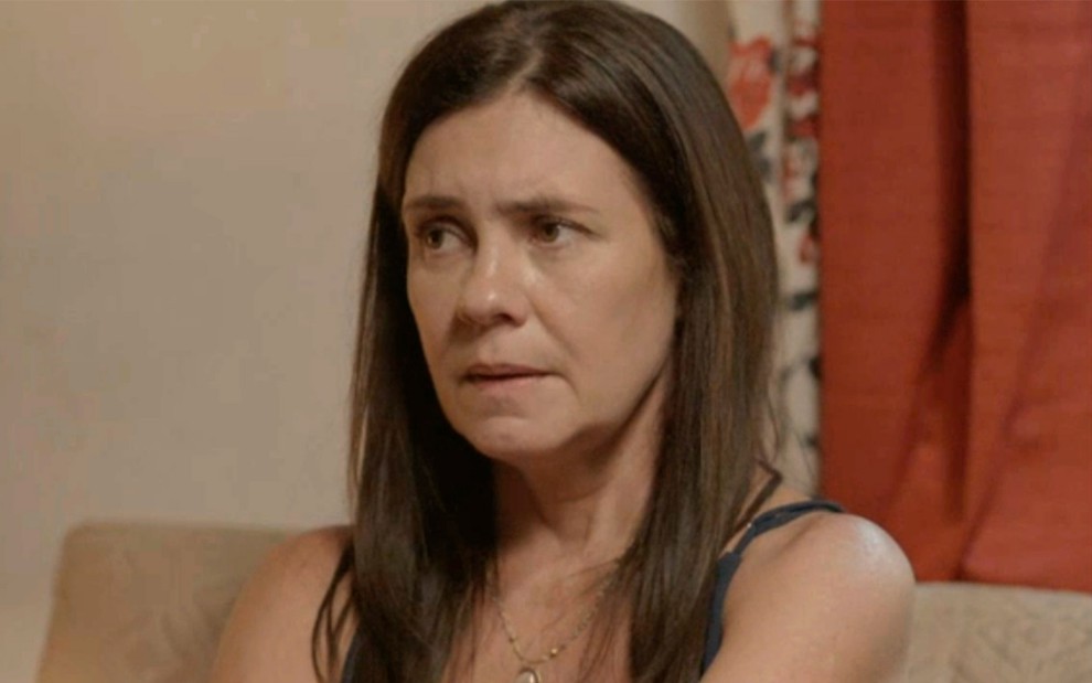 Adriana Esteves em cena de Amor de Mãe: caracterizada como Thelma, personagem olha com desconfiança para alguém fora do quadro