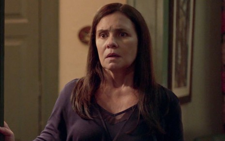 Adriana Esteves caracterizada como Thelma em Amor de Mãe: atriz olha com choque para alguém fora do quadro