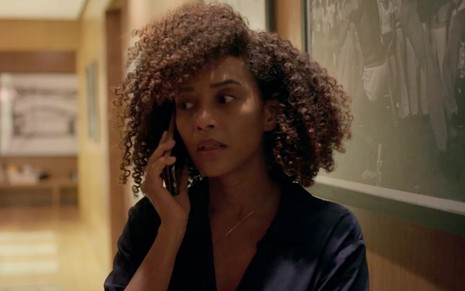 Taís Araujo em cena de Amor de Mãe: caracterizada como Vitória, atriz está com o celular no ouvido e escuta algo com preocupação