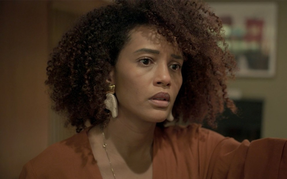 Taís Araujo em cena de Amor de Mãe: caracterizada como Vitória, atriz está em close e olha de maneira assustada para alguém fora do quadro