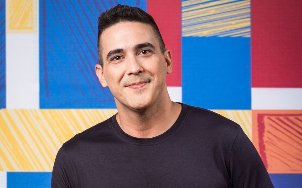 Andre Marques em divulgação de The Voice Kids: apresentador está com camiseta preta e sorri para câmera