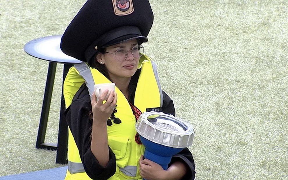 Juliette Freire com um quepe gigante de policial, um colete amarelo e uma lanterna igualmente grande no BBB21