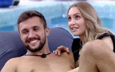O instrutor de crossfit e a atriz Carla Diaz juntos dentro do programa da Globo, Big Brother Brasil; os dois conversam na beira da piscina
