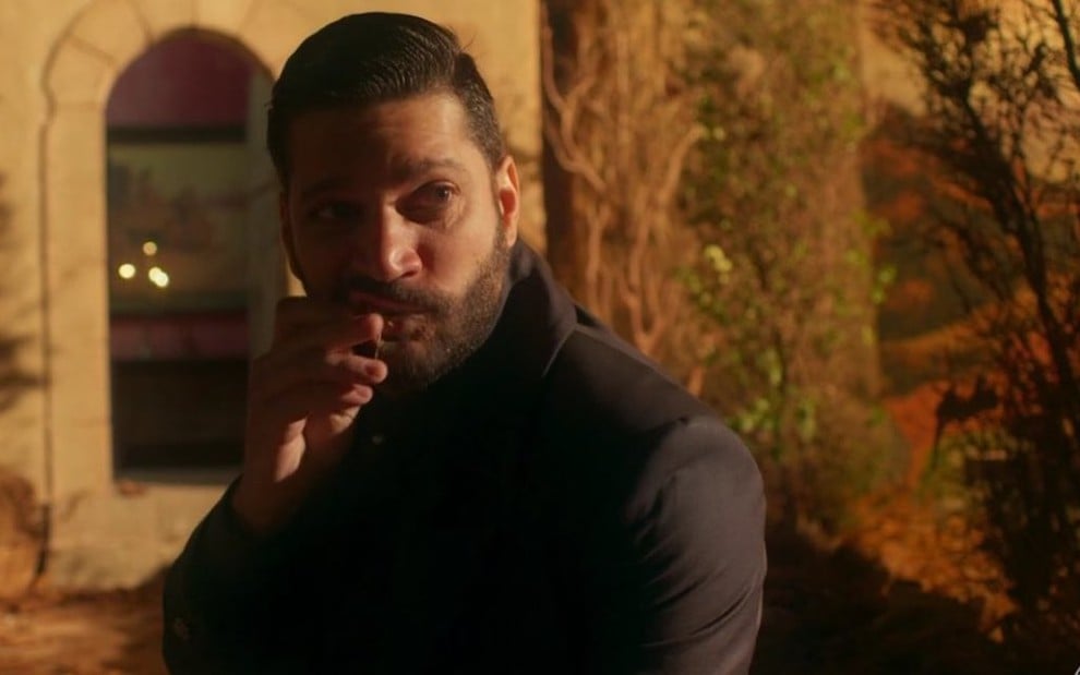 O ator Armando Babaioff passa a mão na barba durante cena da novela Bom Sucesso, em que interpreta o vilão Diogo
