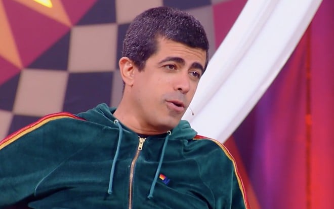 O comediante Marcius Melhem sentado na cadeira de jurado do Gonga La Gonga no Caldeirão do Huck