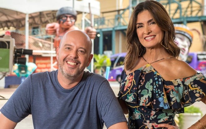 Apresentadores do Carnaval, Alex Escobar e Fátima Bernardes sorriem em escola de samba