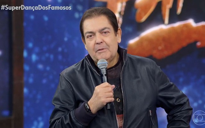 Fausto Silva, o Faustão, de jaqueta de couro no cenário do Domingão do Faustão