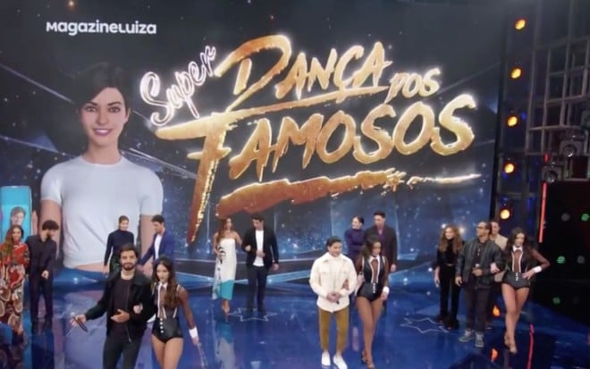 Palco do Domingão do Faustão com o nome da Super Dança dos Famosos no telão do programa e atores e dançarinos espalhados pelo palco