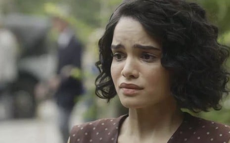 A atriz Carol Macedo, com expressão de choro, caracterizada como a Inês em cena de Éramos Seis