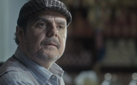 O ator Cássio Gabus Mendes caracterizado como o Afonso em cena de Éramos Seis, com boina, e expressão de enfrentamento