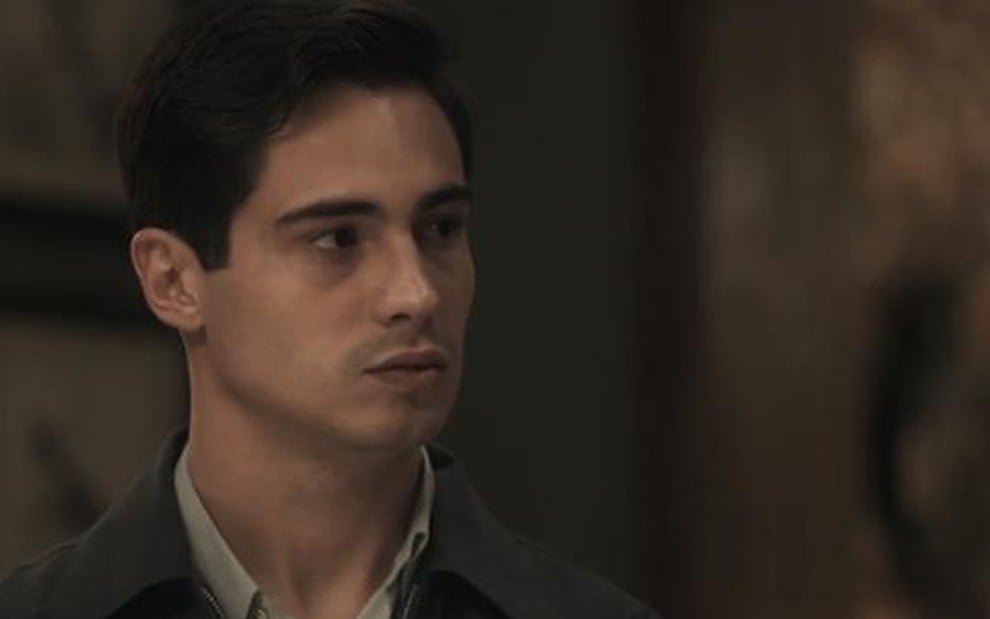O ator Danilo Mesquita caracterizado como o personagem Carlos, de expressão fechada, em cena de Éramos Seis