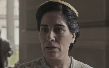 A atriz Gloria Pires caracterizada como Lola, com a expressão assustada e um pequeno chapéu, em cena de Éramos Seis, novela das seis da Globo