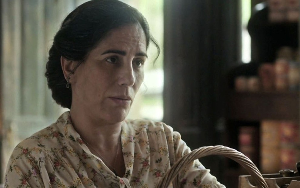 A atriz Gloria Pires com os cabelos presos, olha para a direita com expressão sofrida em cena como a Lola de Éramos Seis