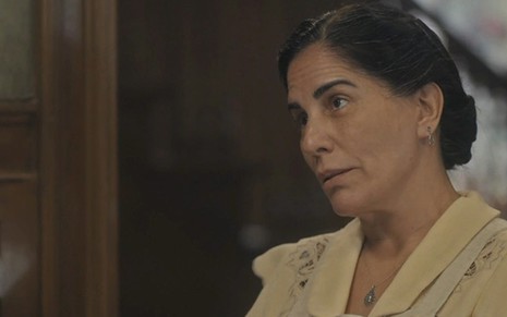 A atriz Gloria Pires, caracterizada como Lola, apresenta expressão de irritação, em cena de Éramos Seis