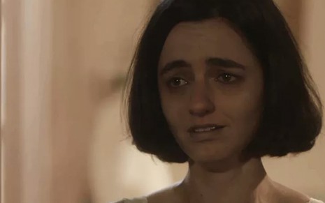 A atriz Julia Stockler, em um close, chora caracterizada como a Justina de Éramos Seis, novela das seis da Globo