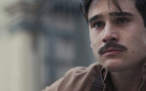 O ator Nicolas Prattes, em um close de seu rosto, com bigode e uma expressão triste, caracterizado como o Alfredo de Éramos Seis
