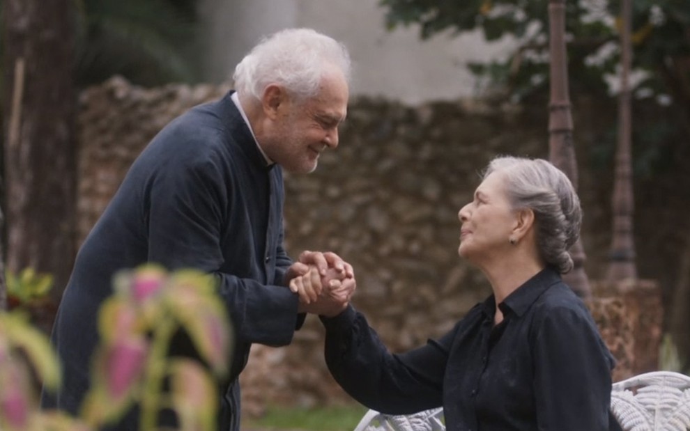O ator Othon Bastos dá a mão para a atriz Irene Ravache em um jardim em cena de Éramos Seis