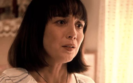 A atriz Simone Spoladore, com expressão de sofrimento, caracterizada como a Clotilde em cena de Éramos Seis