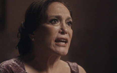 A atriz Susana Vieira, em um close no seu rosto, caracterizada como a Emília de Éramos Seis, grita para alguém fora da cena