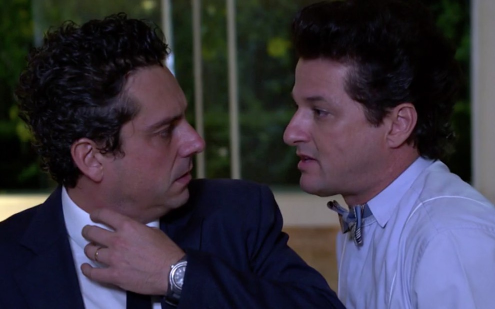 Os atores Alexandre Nero e Marcelo Serrado em cena de Fina Estampa: Nero olha com cara de assustado, enquanto Serrado está com o rosto quase colado ao dele