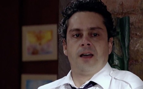 O ator Alexandre Nero, caracterizado como Baltazar, em cena de Fina Estampa: personagem usa camisa branca com gravata preta e tem olhar de atordoado