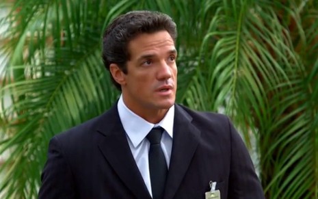 O ator Carlos Machado usa um terno e tem expressão preocupada em cena como Ferdinand na novela Fina Estampa