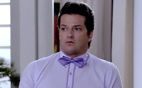 O ator Marcelo Serrado caracterizado como Crô, personagem de Fina Estampa: Crô usa uma camisa lilás e faz cara de surpreso