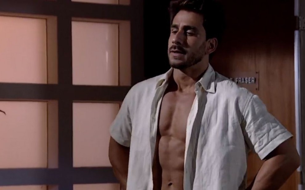 O ator Julio Rocha com uma camisa aberta, mostrando seu abdome, em cena como Enzo na novela Fina Estampa 