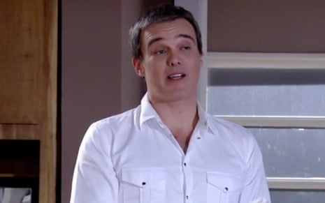 Dalton Vigh caracterizado como René de Fina Estampa, personagem usa camisa branca e sorri para alguém fora do quadro